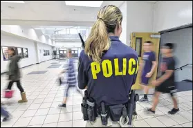  ?? HYOSUB SHIN / HSHIN@AJC.COM ?? Jennifer Presley, a school resource officer at Buford’s Twin Rivers Middle School, conducts a routine check in May. Districts are adding officers to protect students and staff.