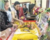  ?? AMANDA MUSTARD/THE NEW YORK TIMES ?? The owners of Kaew, or Wonton, sprinkle petals onto the dog's body at a Buddhist temple.