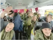  ?? RUSSIAN DEFENSE MINISTRY PRESS SERVICE ?? Russian soldiers wave after they were released Saturday in a prisoner swap with Ukraine. Russia said that 63 of its soldiers were returned.