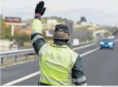  ?? PHOTOGRAPH­ERSSPORTS ?? Un agente de la Guardia Civil ordena el alto a un vehículo en Granada.