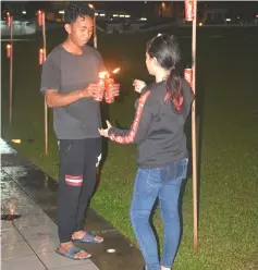  ??  ?? Picture top and botton (right) show workers lighting up the kerosene oil lamps at Sibu Town Square.