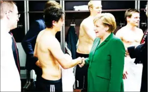  ?? AFP ?? Angela Merkel congratula­tes Germany midfielder Mesut Ozil after their victory over Turkey in a Euro 2012 qualifier at Berlin’s Olympic stadium on October 8, 2010.