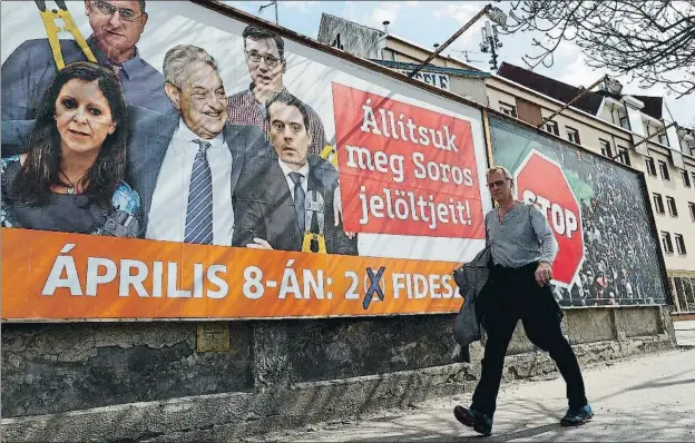  ?? LASZLO BALOGH / GETTY ?? Cartel de Fidesz, que presenta a cuatro candidatos de la oposición en torno al filántropo George Soros, con tenazas para abrir la valla antiinmigr­ación de Orbán