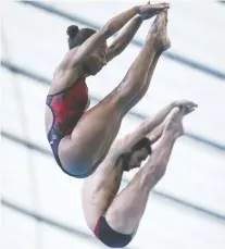  ?? JEFF MCINTOSH/THE CANADIAN PRESS ?? Canada’s Jennifer Abel, left, and Francois Imbeau-Dulac jump their way to a bronze medal in the mixed 3-metre synchro finals event at the FINA Diving Grand Prix on Sunday.