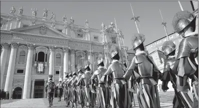  ?? AP/ALESSANDRA TARANTINO ?? The Vatican’s Swiss guards march toward St. Peter’s Basilica on Monday before Pope Francis’ Christmas blessing.