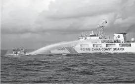  ?? PHILIPPINE COAST GUARD VIA AP ?? A Chinese Coast Guard ship uses water cannons on a Philippine navy-operated supply boat Sunday as it approaches Second Thomas Shoal, locally known as Ayungin Shoal, in the disputed South China Sea.