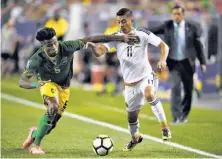  ?? Mark Ralston / AFP / Getty Images ?? Mexico’s Elias Hernandez (right) is tackled by Jamaica’s Alvas Powell during the Gold Cup group-stage match in Denver.