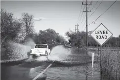  ?? THE NEW YORK TIMES ?? The Cosumnes River washes over a levee road near Sacramento, Calif., on Feb. 23.