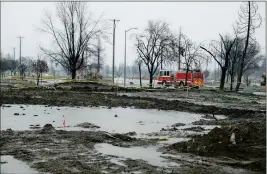  ?? ASSOCIATED PRESS ?? A FIRE TRUCK DRIVES THROUGH THE WILDFIRE damaged Coffey Park neighborho­od Monday as rain water pools where a home once stood in Santa Rosa, Calif.