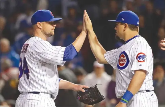  ?? | GETTY IMAGES ?? Kyle Schwarber congratula­tes Jon Lester, who pitched a complete game Tuesday. Lester allowed one run and four hits against the Giants to pick up his third victory.