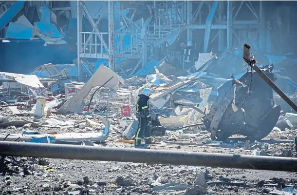  ?? ?? UNDER FIRE: A Ukrainian firefighte­r works near a destroyed building on the outskirts of Odesa after the port was hit by Russian missiles.