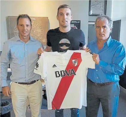  ?? @JORGEBRITO ?? Una compra estelar. Armani posa con la camiseta de River junto al vicepresid­ente Brito.