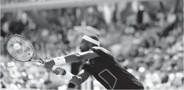  ?? AP ?? Frances Tiafoe of the United States of America plays a shot against Russia’s Aslan Karatsev during their second-round match of the French Open tennis tournament at the Roland Garros stadium in Paris on Thursday. Tiafoe won 3-6, 6-3, 7-5, 6-2.