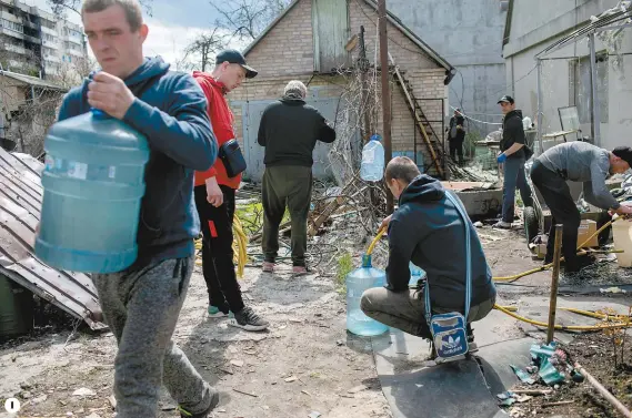  ?? ?? 1 1
Des résidents d’Irpin font des provisions d’eau près d’une maison endommagée par les bombardeme­nts russes.