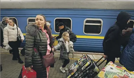  ?? Carolyn Cole Los Angeles Times ?? VICTORIA TETERYA and her young daughter, Milana, wait for a train in Odesa, Ukraine, on Thursday after fleeing Kherson.