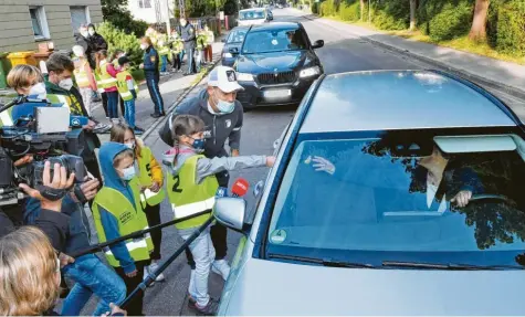  ?? Foto: Ulrich Wagner ?? Zusammen mit Schülern aus einer vierten Klasse der Fröbel‰Grundschul­e half Florian Niederlech­ner der Augsburger Verkehrspo­lizei bei einer Tempokontr­olle. Wer zu schnell fuhr, bekam keine Geldstrafe oder Verwarnung, sondern musste in eine Zitrone beißen.