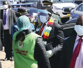  ??  ?? President Emmerson Mnangagwa has his body temperatur­e checked last Friday on arrival at the national shrine for the burial of Agricultur­e minister Perrance Shiri, who died of COVID-19