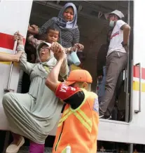  ?? FEDRIK TARIGAN/ JAWA POS ?? HATI-HATI, BU: Petugas membantu penumpang turun dari KRL DepokStasi­un Kota saat perjalanan menuju Stasiun Manggarai terhenti karena gangguan listrik di area Bukit Duri kemarin.