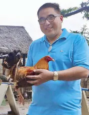  ?? Photos By ERNIE PENAREDOND­O ?? Remar de Leon at his farm with his favorite rooster the Ormoc Gold