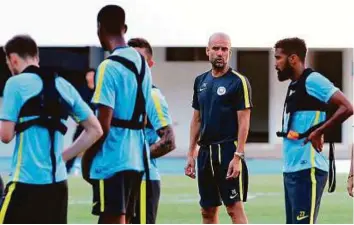  ?? Reuters ?? Manchester City team manager Pep Guardiola (second from right) puts his players through a rigorous session on their arrival in Shenzhen after missing the match against Manchester Utd.