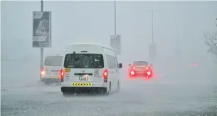  ?? AFP ?? Vehicles drive down a flooded road during torrential rain in Dubai on Tuesday.