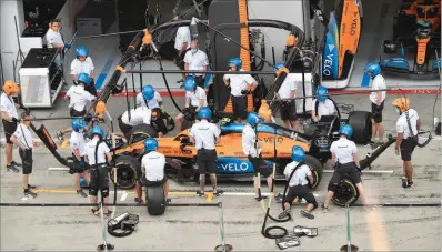  ??  ?? McLaren’s mechanics practice a tyre change on the car of British driver Lando Norris on Thursday, on the eve of the first practice session at the Austrian Formula One Grand Prix in Spielberg, Austria. (AFP)