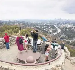  ?? Brian van der Brug Los Angeles Times ?? TOURISTS enjoy the view from a Mulholland Drive overlook.