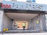  ?? JIM THOMPSON/JOURNAL ?? Constructi­on workers put some finishing touches on the new Lobo Rainforest building at Central and Broadway in Downtown.