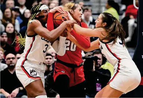  ?? Jessica Hill/Associated Press ?? UConn’s Aaliyah Edwards, left, and Caroline Ducharme, right, pressure St. John’s Rayven Peeples, center, on Tuesday in Hartford.