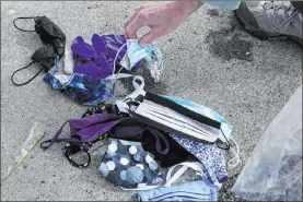  ?? Jeff Chiu The Associated Press ?? Lynn Adams, president of the Pacifica Beach Coalition, shows face masks and gloves that were found discarded during a monthly beach cleanup last week in Pacifica, Calif.