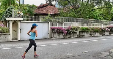  ??  ?? Eye of the storm: A file photo of a woman jogging past 38, Oxley Road in Singapore. — AFP