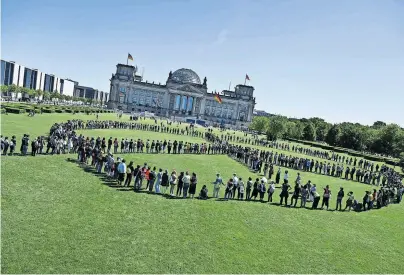  ?? [ FP/John Macdougall ] ?? Give peace a chance! Aktivisten formieren sich vor dem Berliner Reichstag zu einem riesiges Friedensze­ichen.
