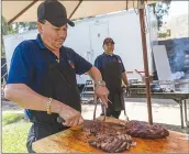  ?? ?? Chris Torres/The Signal Ricard Gomez, co-owner of Xalisco Bar & Grill, slices barbecue tri-tip to serve at the Xalisco Bar & Grill food booth.