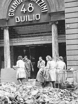  ??  ?? Un’immagine di Duilio 48, l’antesignan­o di Coin, con le commesse alle prese coi detriti dell’Alluvione nel ‘66. Sotto, l’ingresso del grande magazzino ai giorni nostri