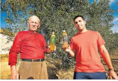  ??  ?? Los Mellado, padre e hijo, con dos botellas de su producción de aceite.