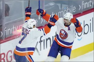  ?? MATT SLOCUM — THE ASSOCIATED PRESS ?? New York Islanders’ Nick Leddy, right, and Jordan Eberle celebrate after Leddy was credited with scoring the winning goal in overtime that gave the Islanders a 1-0victory over the Flyers Sunday night at the Wells Fargo Center.