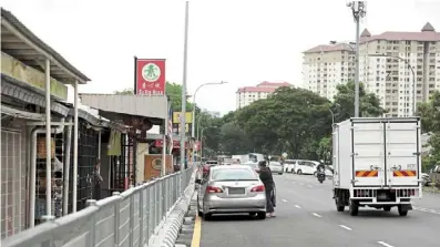  ?? ?? new fencing along Jalan Kepong Baru reduces customers’ access to the businesses, traders claim. photos: yap Chee HONG/THE star