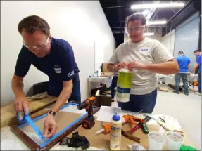  ?? ZACHARY SRNIS — THE MORNING JOURNAL ?? Brad Schmidt, national sales manager at PolyOne, left, and Alex Krutkiewic­z, pricing analyst at PolyOne, work on making doors Aug. 8 for Little Free Libraries.