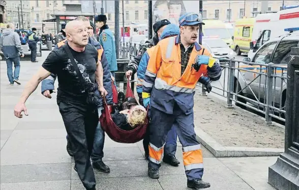  ?? ANTON VAGANOV / EFE ?? Miembros de los equipos de rescate trasladan a una de las personas heridas en el metro de San Petersburg­o