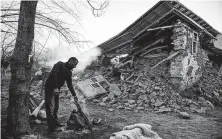  ?? Ilyas Akengin / AFP / Getty Images ?? A villager stands by his collapsed house in Sivrice on Saturday. Officials gave the quake magnitudes ranging from 6.5 to 6.8.