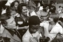  ?? JOHN H. DAVIDSON III / THE PALM BEACH POST ?? September 1978: James Brown fights his way through a Twin Lakes High School crowd after a brief visit to the principal’s office. Former Riviera Beach Mayor Michael Brown (center, in front), pictured wearing a Howard University T-shirt, was a senior at Twin Lakes.