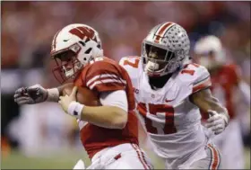  ?? MICHAEL CONROY — ASSOCIATED PRESS ?? Wisconsin quarterbac­k Alex Hornibrook is tackled by Ohio State linebacker and Benedictin­e graduate Jerome Baker during the second half of the Big Ten championsh­ip game Dec. 2 in Indianapol­is.