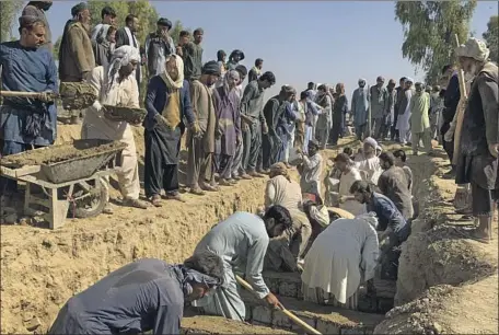  ?? Sidiqullah Khan Associated Press ?? IN THE SOUTHERN AFGHAN province of Kandahar, men dig a mass grave for the victims of Friday’s suicide bombing that killed dozens of people at a mosque. In total, 63 graves were prepared, but the Taliban government maintained that the official death toll was 47.