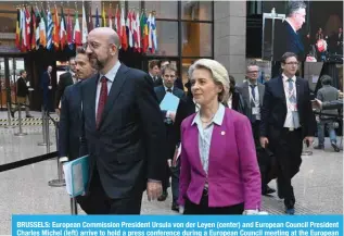  ?? — AFP ?? BRUSSELS: European Commission President Ursula von der Leyen (center) and European Council President Charles Michel (left) arrive to hold a press conference during a European Council meeting at the European headquarte­rs in Brussels.