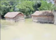  ??  ?? Huts submerged in flood water in a Gonda village and NDRF team taking relief material for flood victims in Gorakhpur.