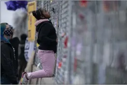  ?? JOHN MINCHILLO — THE ASSOCIATED PRESS ?? Nevaeh Gibson inspects a two-layer fenced perimeter around the Police Department in Brooklyn Center, Minn., on Thursday during a protest in response to the shooting death of Daunte Wright.