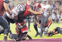  ?? ANDRES LEIGHTON/FOR THE JOURNAL ?? New Mexico State running back Larry Rose III dives into the end zone for a touchdown against Arkansas State on Saturday.