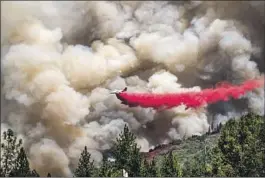  ?? Noah Berger Associated Press ?? AN AIR TANKER drops retardant on the Oak fire in Mariposa County near Yosemite National Park on Sunday. The blaze is now more than 19,000 acres.