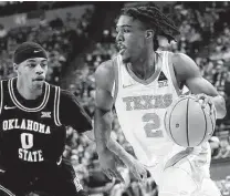  ?? Chris Covatta / Getty Images ?? Texas' Marcus Carr, driving around Oklahoma State's Avery Anderson III, finished with 14 points for the Longhorns.