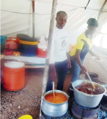  ??  ?? Waiters at Oluwalosey­i served. Joint Jabi stir a pot of soup as customers wait to be